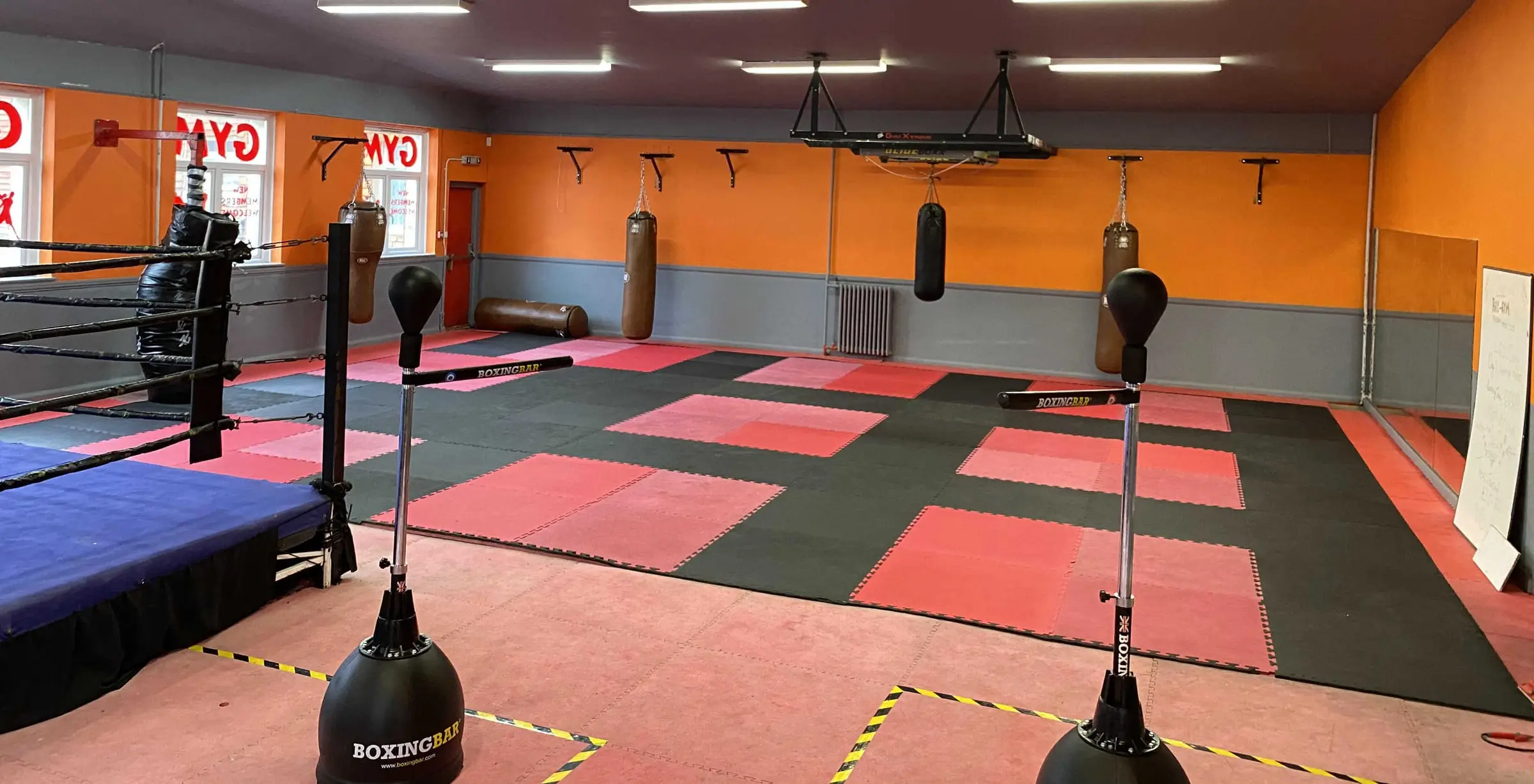 Matted fight school room with punch bags at The Bar Gym Worthing