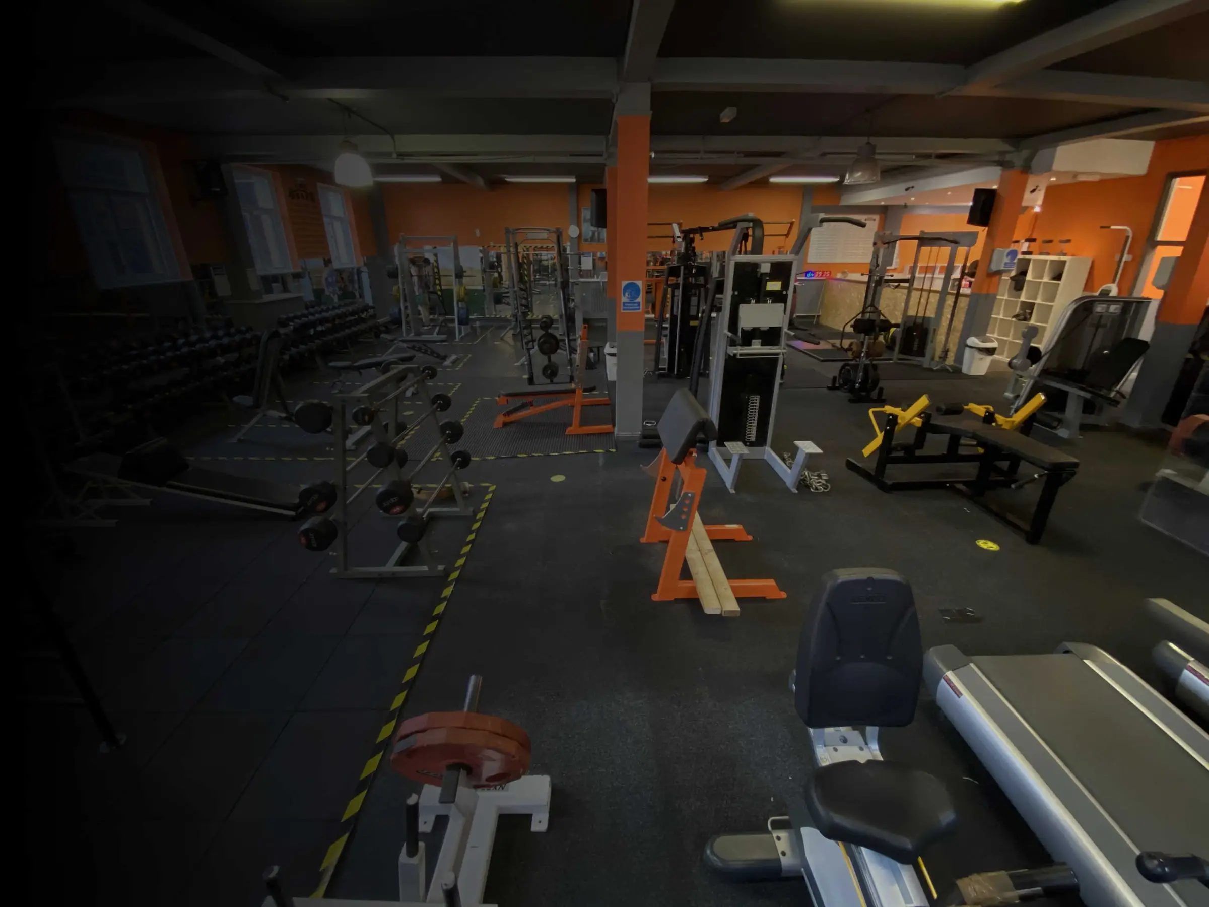 Plate-loaded machines and racks on the gym floor at The Bar Gym Worthing