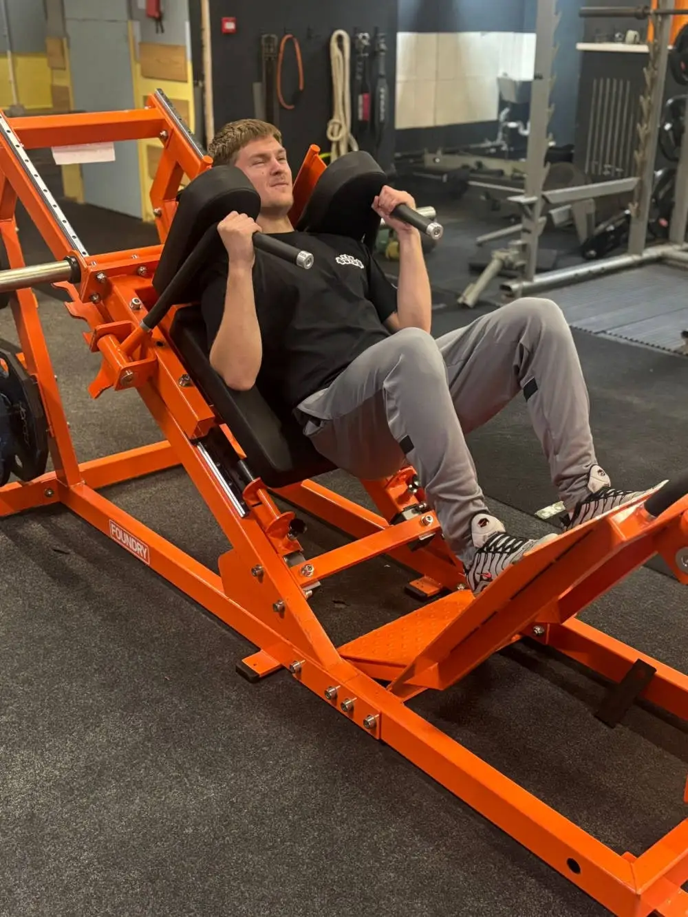 Member training on the plate-loaded leg press, The Bar Gym Worthing